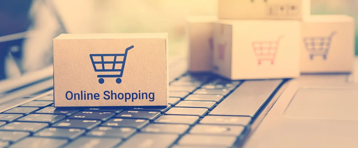 Box with a shopping cart on a laptop keyboard, for online store hosting